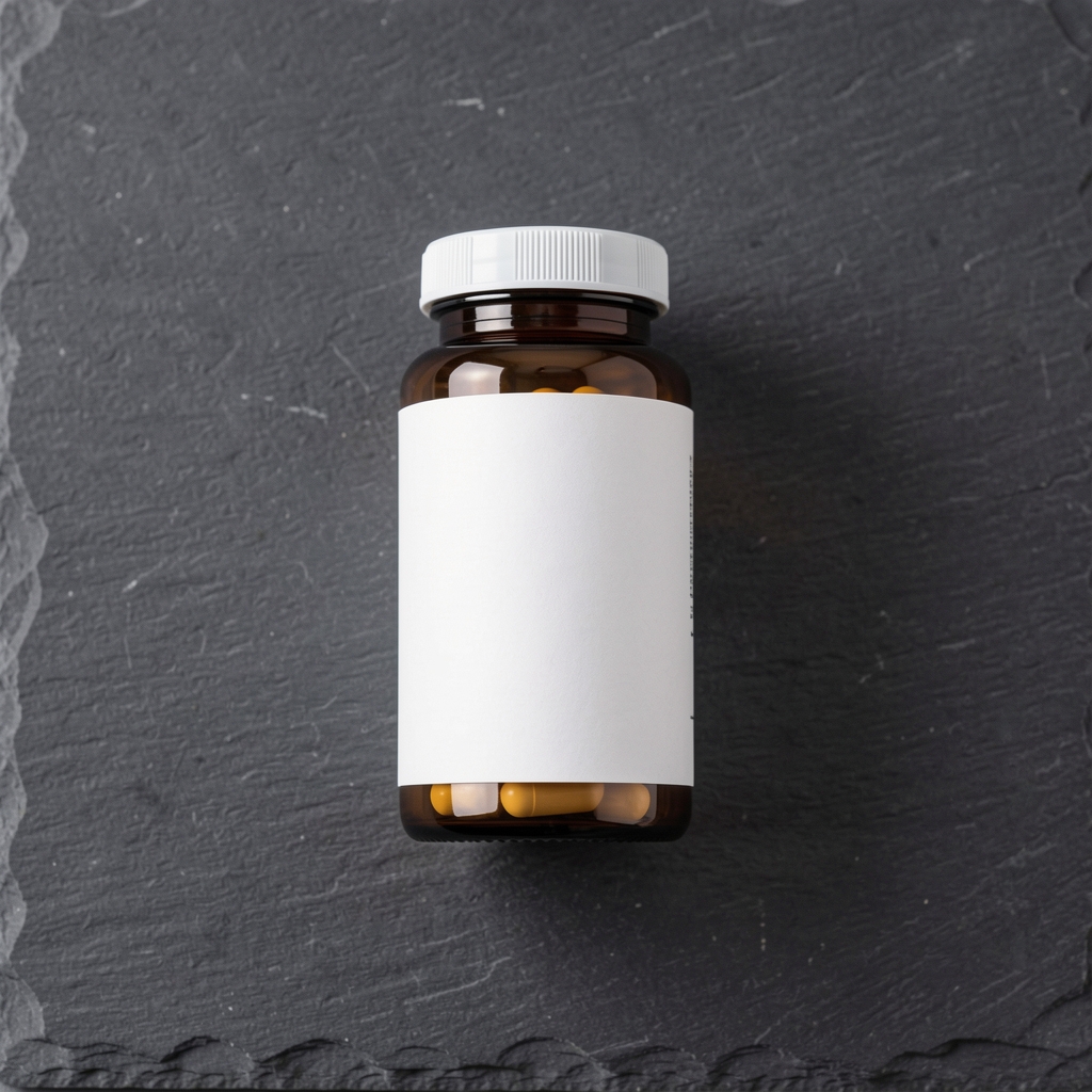 B-vitamin complex capsule bottle with minimalist label on a dark grey slate background in clean workspace lighting